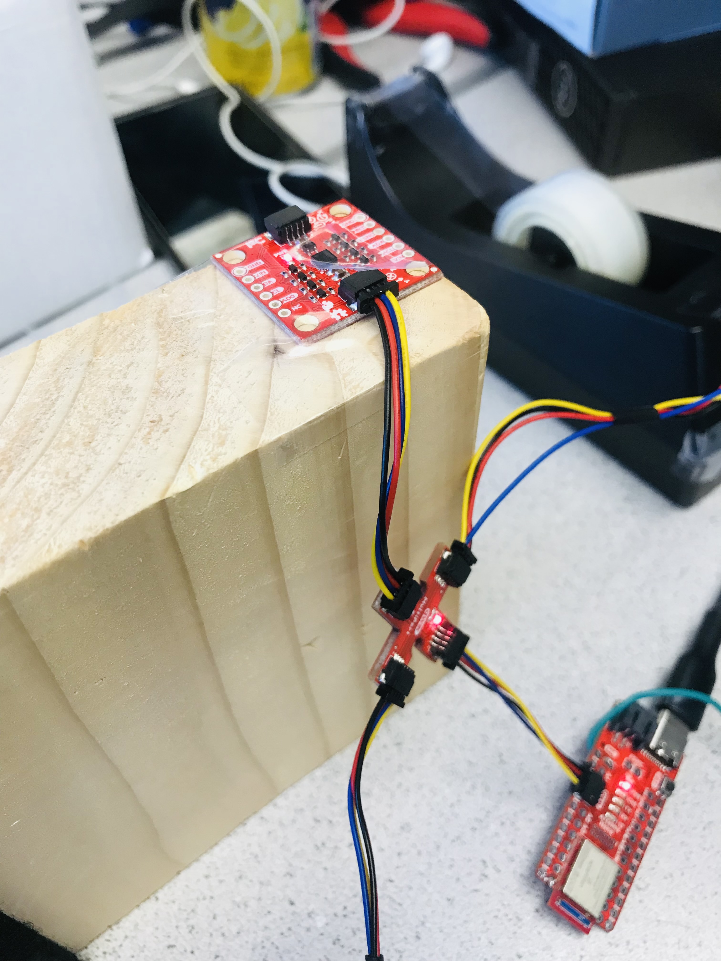 IMU connected to the QWIK multiport adapter connected to the Artemis. The IMU is taped on top of a wooden block.