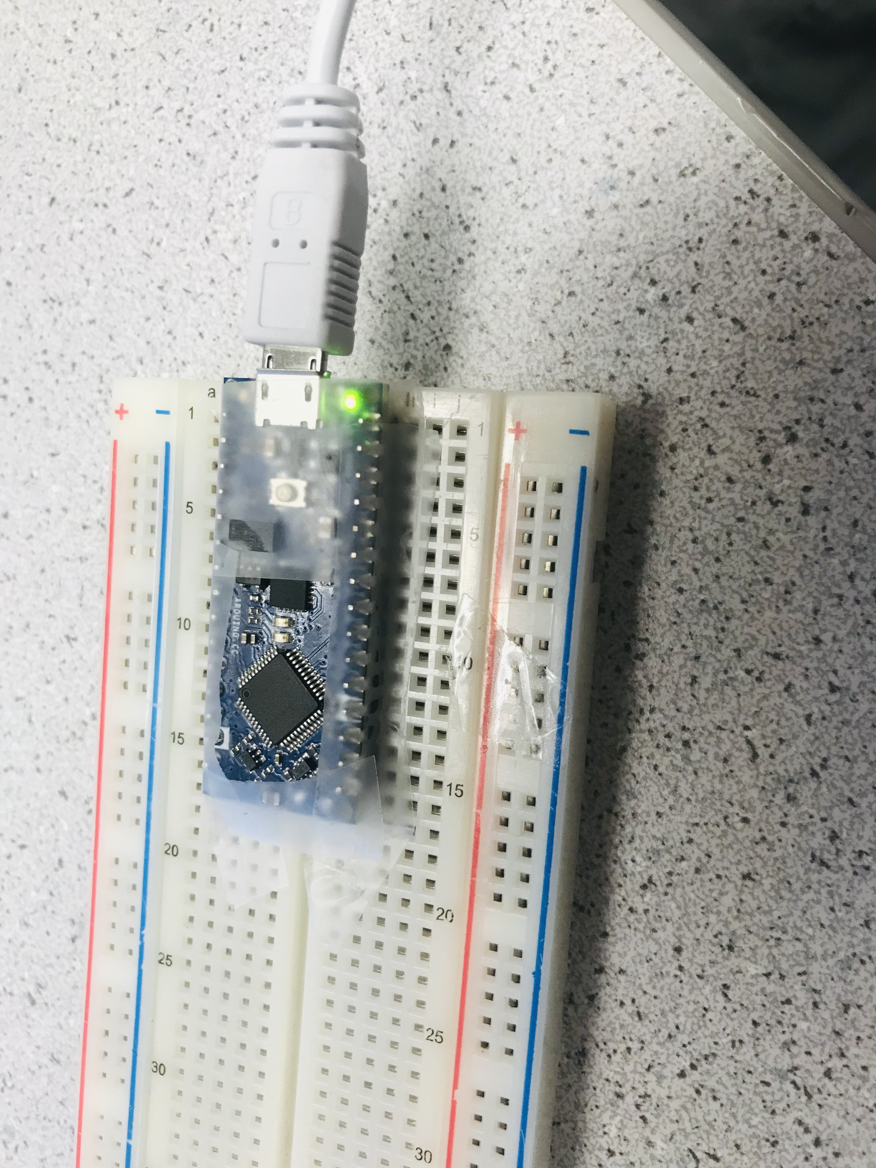 Arduino placed in breadboard with tape protecting it